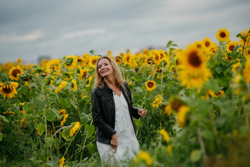 A woman walking through a field of sunflowers