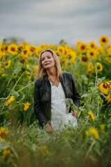 A woman walking through a field of sunflowers