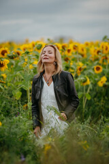 A woman walking through a field of sunflowers