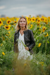 A woman walking through a field of sunflowers