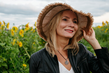 A woman walking through a field of sunflowers