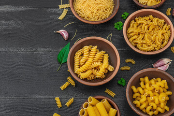 Pasta. Various kinds of uncooked pasta and noodles over wooden background. Traditional Italian