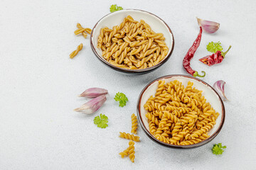 Pasta. Various kinds of uncooked pasta and noodles over light stone background. Traditional Italian