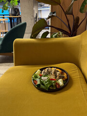 A plate of potato pancakes with creamy mushroom chicken and fresh salad is placed on a mustard...