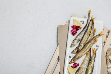 Smoked smelt with fresh lemon and herbs. Salted fish with marine decor. Trendy dish, sea rope