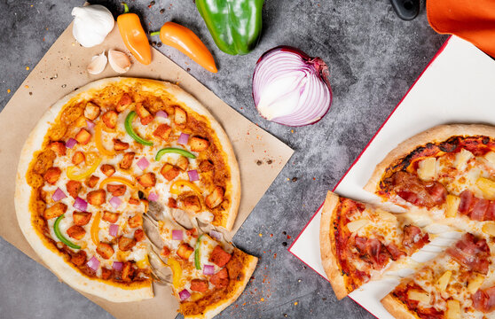 Butter Chicken Pizza and Hawaiian Pizza Overhead shot with vegetables