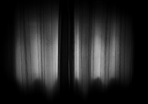 Fotografia de um quarto escuro com luz entrando apenas pela cortina da janela, fotografia em preto e branco, expressando sentimentos ocultos e reservados. 