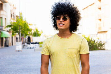 Young tourist exploring city center wearing sunglasses and smiling