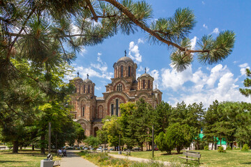 Tasmajdan Park with St. Mark Orthodox Church in neo-Byzantine style under a sunny blue sky, surrounded by greenery and benches. Belgrade, Serbia


