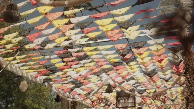 Rows of colorful festival bunting under a bright summer sky in Algarve, Portugal