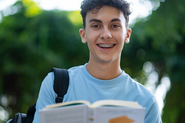 Waist up of a smiling teen with a book in hands