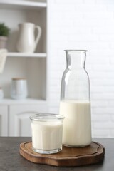 Dairy products. Fresh milk in glass and bottle on gray textured table indoors