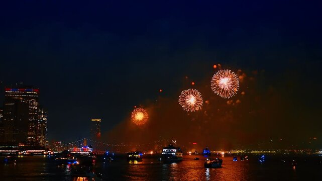 Stunning show with amazing fireworks over the East River in New York, USA. Multiple boats are standing on the river.