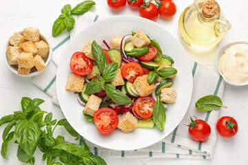 Delicious salad with croutons and ingredients on white wooden table, flat lay
