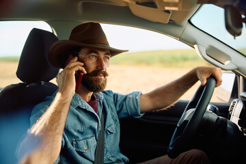 Farmer talking on smart phone while driving his truck.