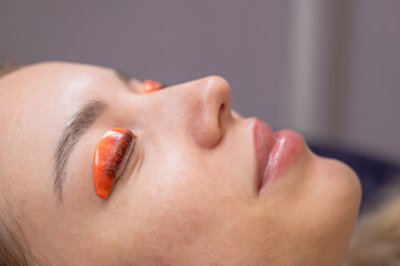 Caucasian woman undergoing eyelash lamination procedure. 