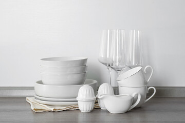 Different clean white dishware and glasses on counter in kitchen