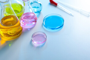 Laboratory glassware with different samples on light table, closeup
