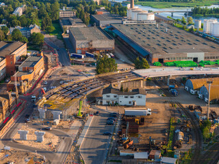 Partially built bridge with scaffolding and equipment in Riga, Latvia, surrounded by industrial...