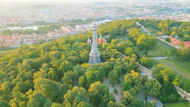 Experience the breathtaking sunrise illuminating the Petrin Lookout Tower in Prague. The vibrant colors highlight the beauty of the city and surrounding nature, creating a serene atmosphere.