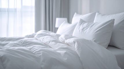 Close-up shot of a neatly made bed with fluffy white pillows and bedding, bathed in natural light