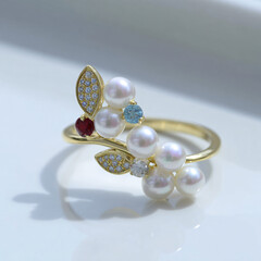 Elegant pearl ring with gemstones, gold band, and diamond accents.