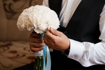 Groom Holding White Carnation Bouquet, Wedding Day, Formal Attire, Elegant Celebration, Light Blue...