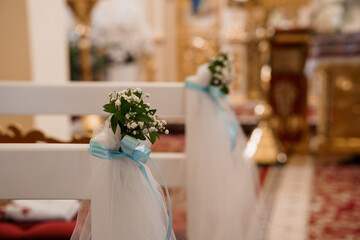 Elegant Wedding Ceremony Pew Decorations with Blue Ribbon and Baby's Breath in Church Setting
