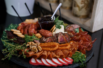 Gourmet Charcuterie Board with Artisanal Meats, Cheeses, Walnuts, and Berries on Slate Platter Dark...