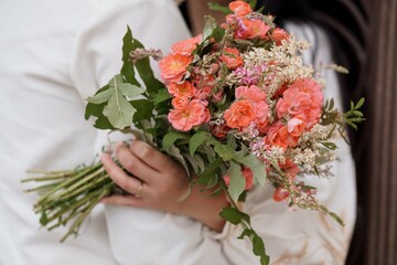 A Woman Holding a Romantic Bouquet of Peach Roses and Wildflowers, Soft Focus, Wedding Theme,...