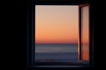 window offers stunning view of sunset and forecast of light creating enchanting atmosphere