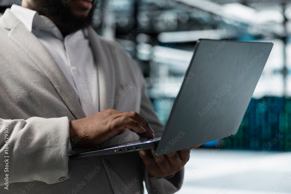 Poster close up of data center worker running error checking utilities on laptop, automating anomaly detect