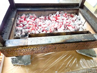 White charcoal details for searing food on a grill photographed from the side. barbecue fire. The sausages are grilled over charcoal until golden brown.
Hot charcoal on the grill, preparation for barb