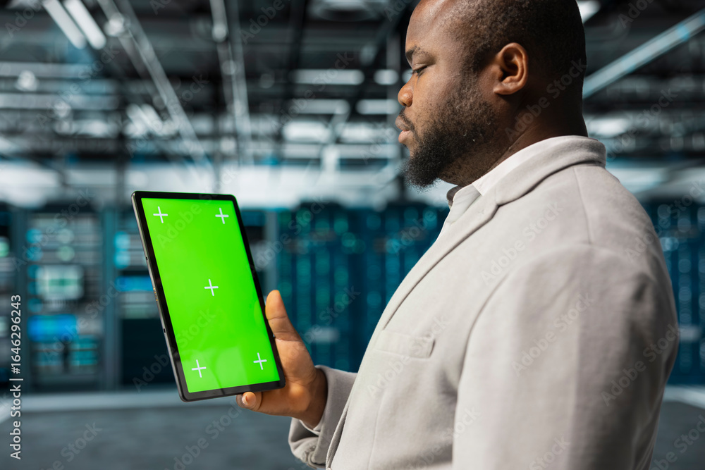 Poster close up of data center computer scientist using green screen tablet in data center, reviewing confi