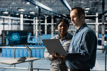 Teamworking data center technicians analyzing equipment performance, resolving technical issues....