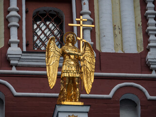 Obraz premium Golden Angel Figure Holding Cross at Resurrection Gate