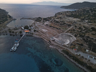 Ancient Roman amphitheater ruins dramatically positioned on coastal cliffs overlooking crystal...