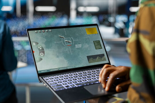 Close up of black soldier in control center server farm uses AI tools to detect cyber threats. Male military personnel using high tech software to secure national security, anti terrorism.