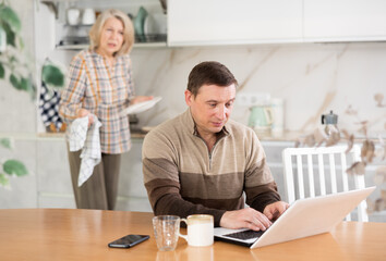 Family quarrel, mother blaming son, son is busy with laptop