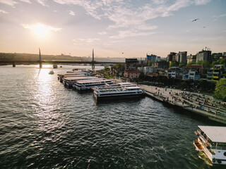 Golden Horn at sunset in Istanbul Turkey water reflects the Halic Metro Bridge and moored ferries...