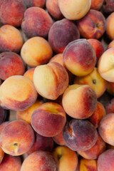 Fresh peaches stacked together at a local market during summer