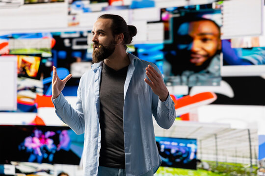 With a hands free microphone, male trend setter hosts a live presentation offering insight for innovation. Speaker discussing with the audience about online engagement, boosting visibility.