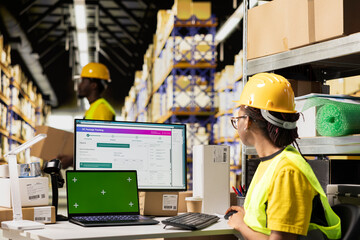 E-commerce worker registering airway bill numbers in the system with mockup, using shipping labels...