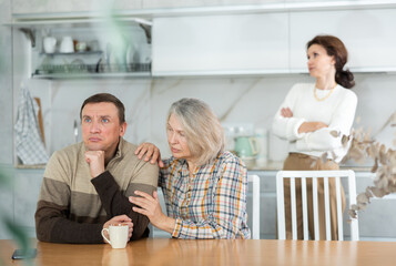 Family quarrel, old woman calming man, all are upset and dissatisfied