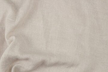Natural beige linen fabric texture with soft wrinkles, top view background
