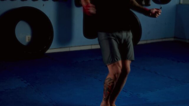 Man training jump rope exercise in boxing gym