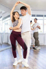 Young man and young woman dance ballroom dance waltz in studio