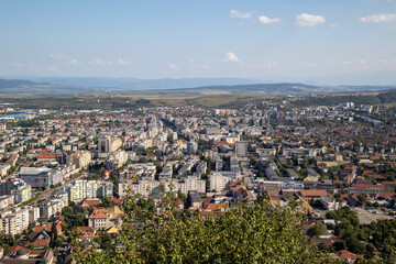 expansive aerial view of the city of deva, romania, showcasing a mix of urban and residential...