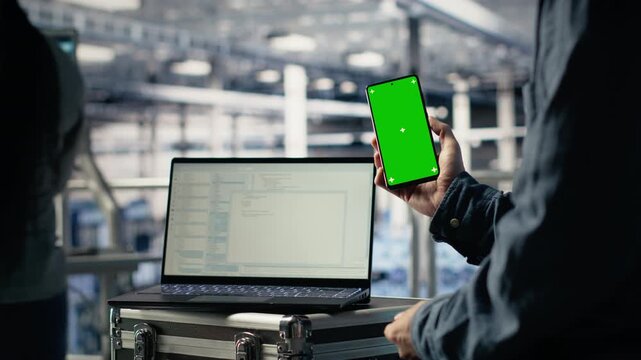 Server room software developer using mockup phone while waiting for updates to finish installing. Data center engineer uses green screen smartphone, waiting for code to finish compiling, camera B