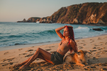 young woman on a beautiful beach with her dog